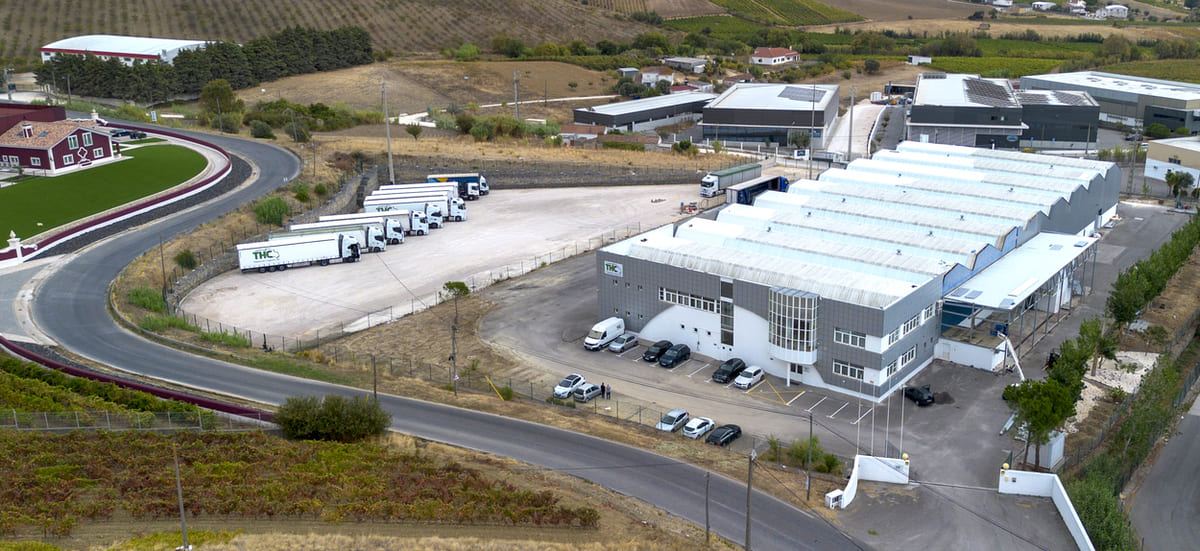 Instalações da THC Transportes em Portugal, com armazéns e camiões prontos para operações logísticas e transporte nacional e internacional.