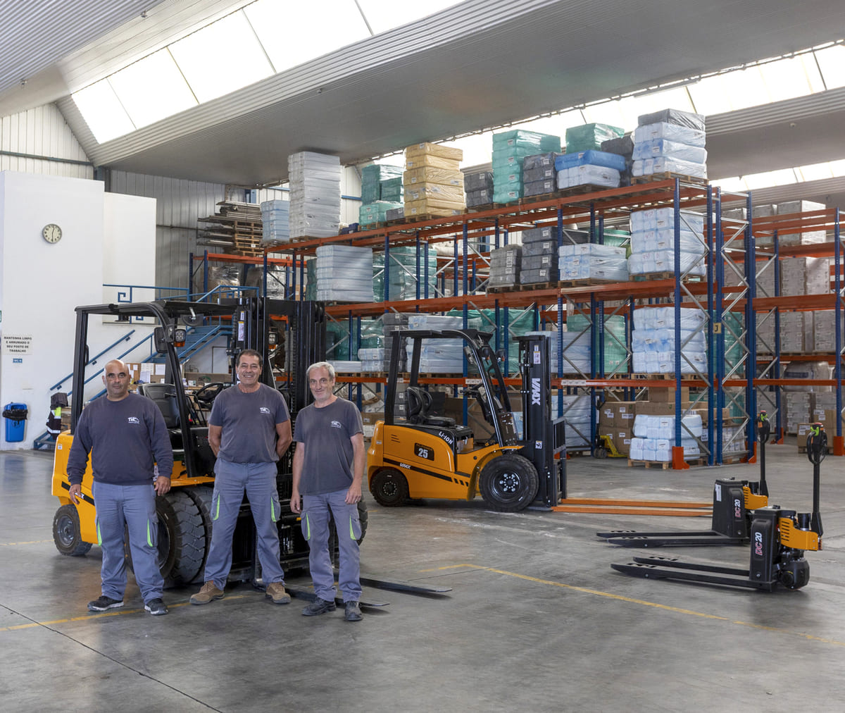 Equipa da THC Transportes e Logística com empilhadores no armazém, preparada para operações de carga e distribuição em Portugal.